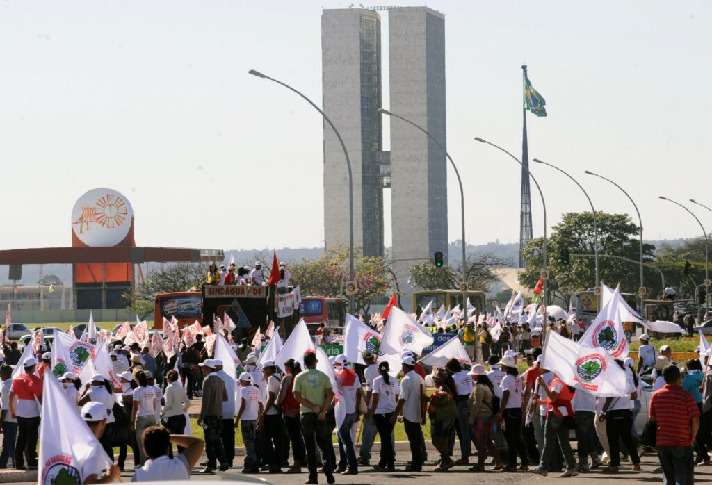 Menschen protestieren mit schwenkenden Fahnen gegen Staudammprojekte in Brasilien